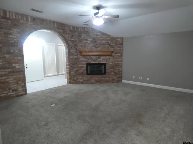 a view of empty room with a fireplace
