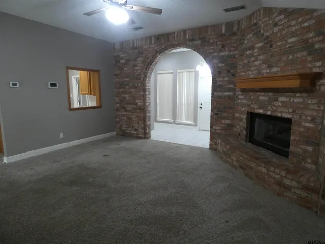 an empty room with windows and fan