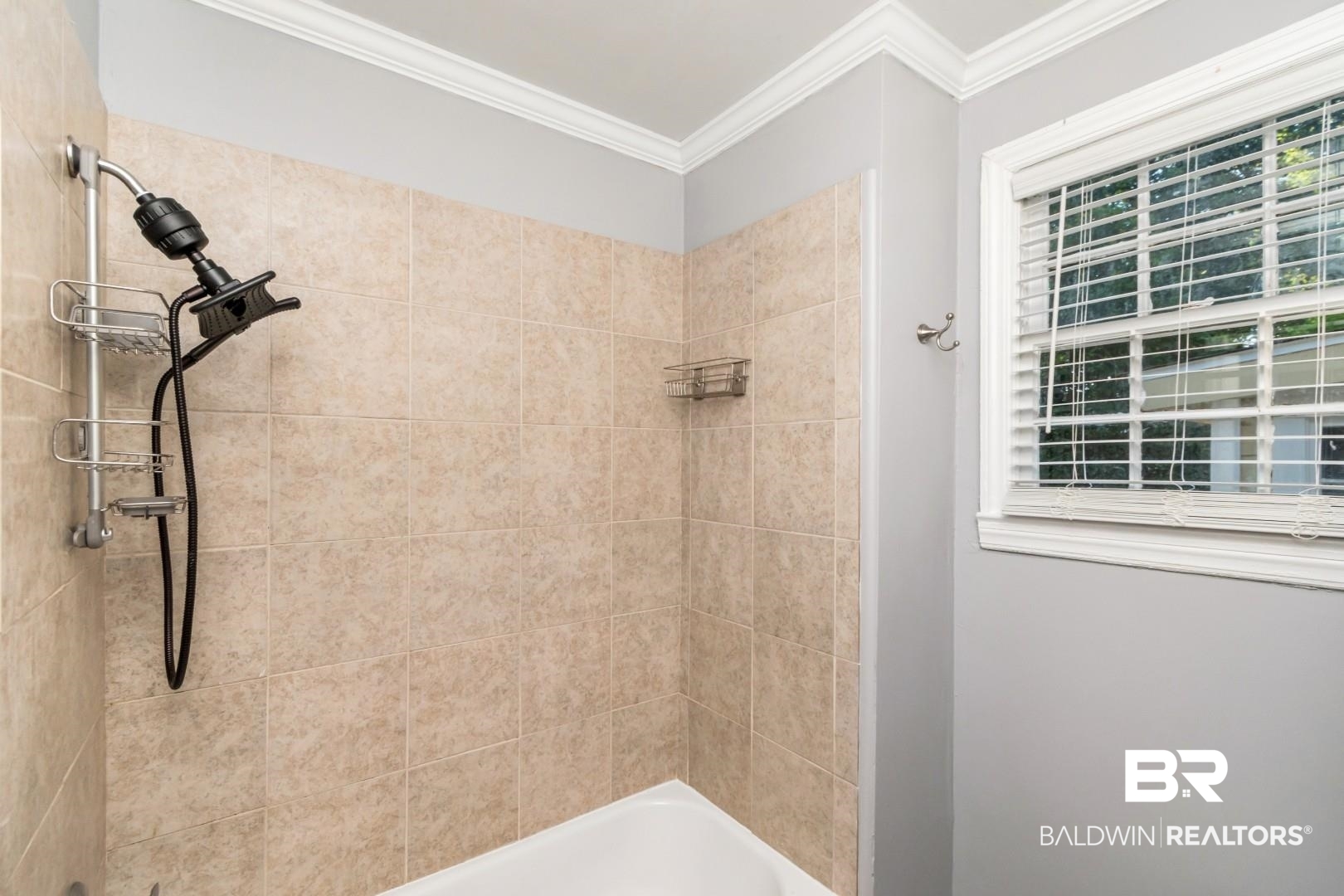 263 Border Drive East Mobile, AL 36608 - Photo 18 of 27 Bathtub with tan tiled surround, crown molding, and a window with blinds
