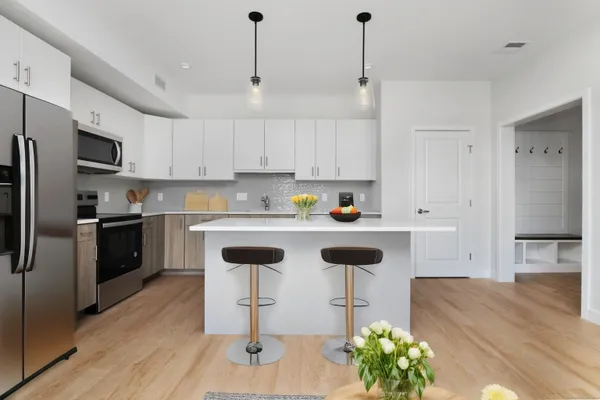 a kitchen with stainless steel appliances granite countertop a sink a stove a refrigerator and island with wooden floor