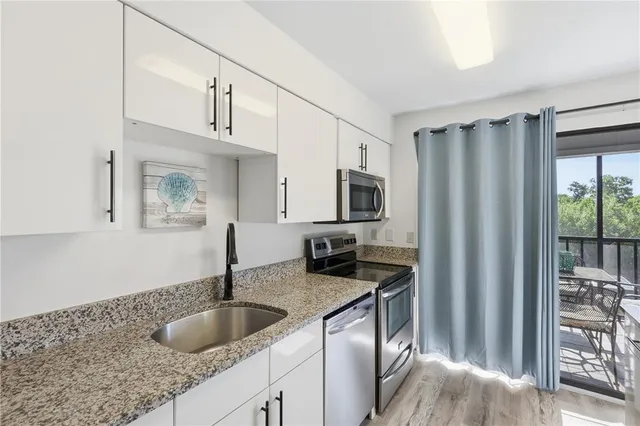 a kitchen with stainless steel appliances granite countertop a sink refrigerator and microwave