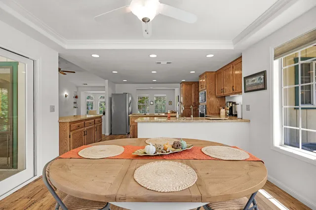 a kitchen with stainless steel appliances kitchen island granite countertop a stove a kitchen island a dining table and chairs