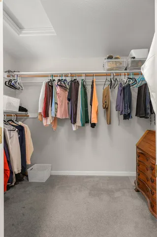 a view of walk in closet with clothes and shoes