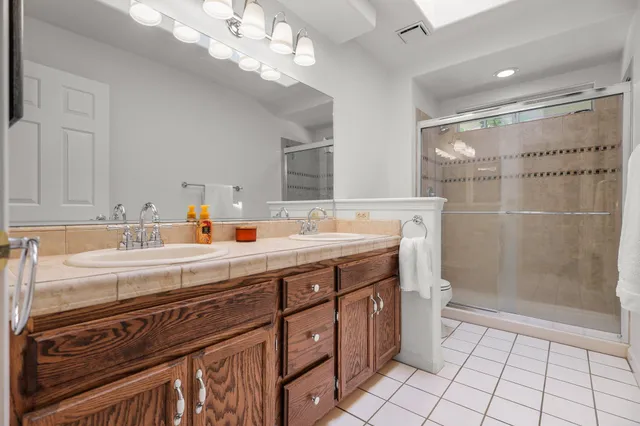 a bathroom with a sink a toilet a mirror and shower