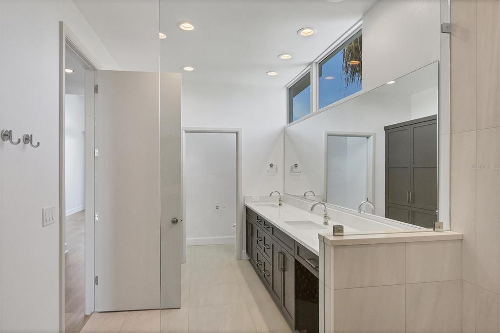 5801 Gulf Of Mexico Drive Longboat Key, FL 34228 - Photo 18 of 52 a bathroom with a double vanity sink and a mirror