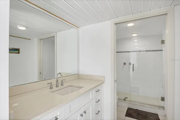 a bathroom with a shower sink vanity and mirror