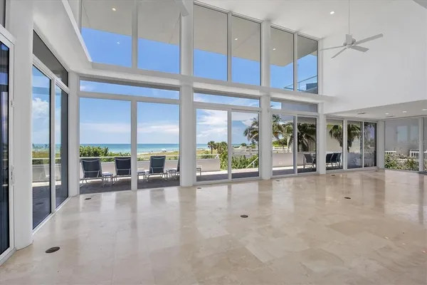 an empty room with floor to ceiling window and an outdoor view