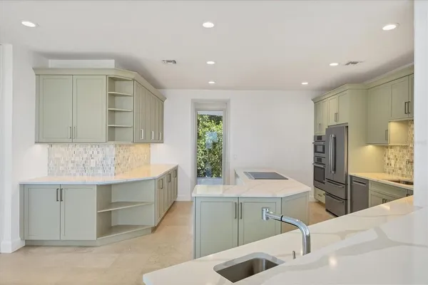 a kitchen with sink refrigerator and microwave