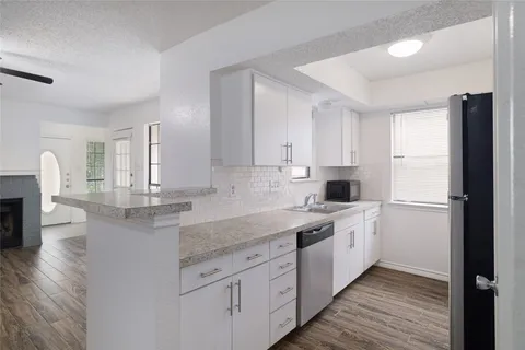 a kitchen with stainless steel appliances granite countertop a sink and cabinets
