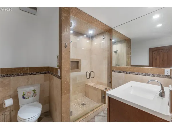 a bathroom with a sink a toilet a mirror and shower