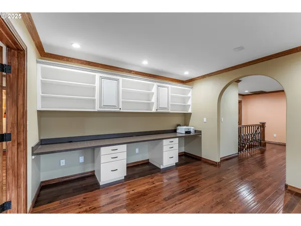 a room with stainless steel appliances wooden floor and view living room