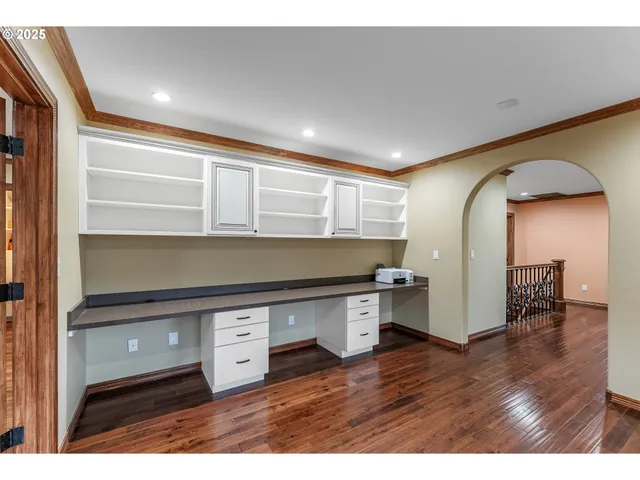 a room with stainless steel appliances wooden floor and view living room