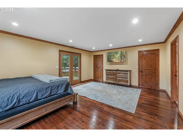 a spacious bedroom with a bed and wooden floor