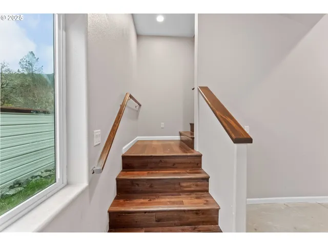 a hallway with wooden floor table and chairs