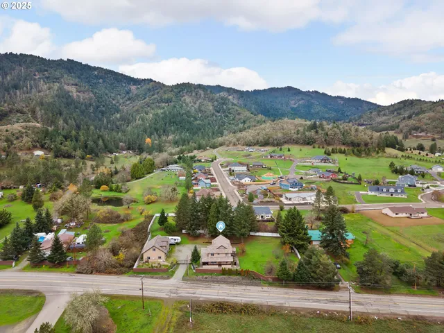 an aerial view of residential houses with outdoor space and river