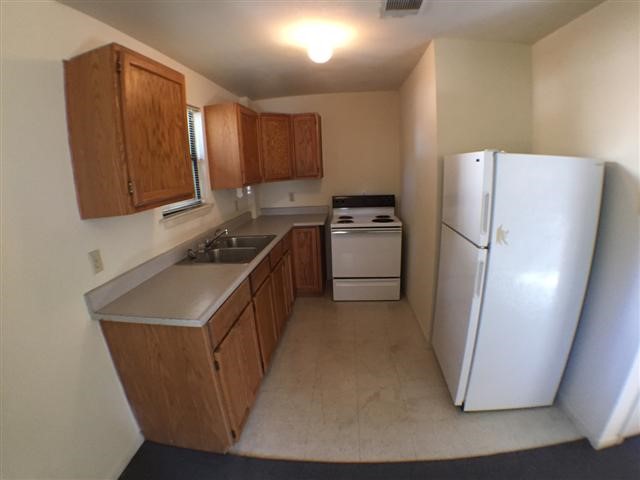 a kitchen with stainless steel appliances a refrigerator a sink a stove a microwave a counter top and a cabinets