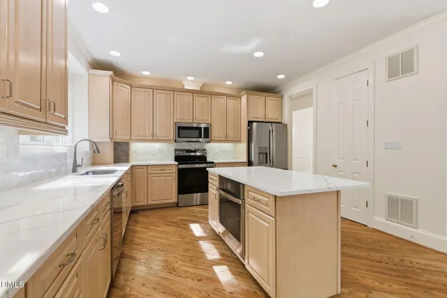 a kitchen with kitchen island white cabinets appliances and wooden floor