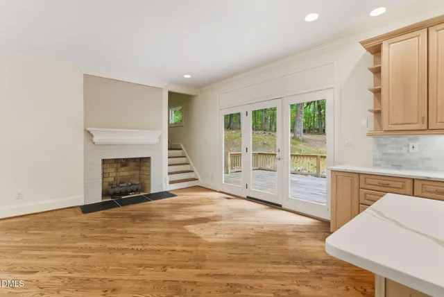 a view of an empty room with a kitchen and a window