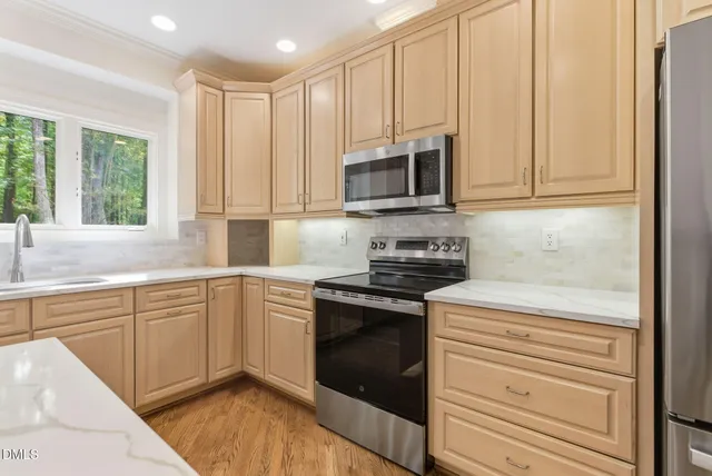 a kitchen with stainless steel appliances granite countertop a stove a sink and a microwave