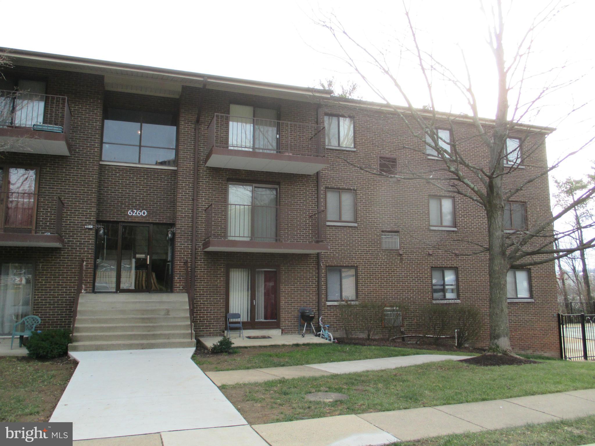 6260 Edsall Road, Unit 403 Alexandria, VA 22312 - Photo 2 of 15 a front view of a brick house with a yard