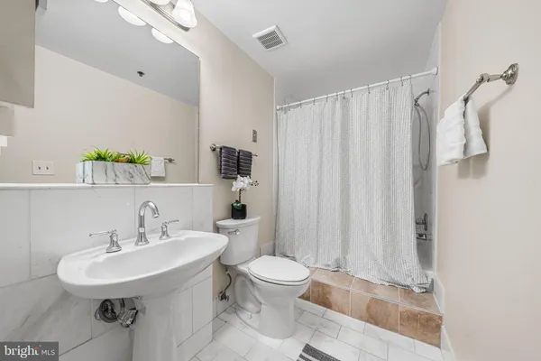 a bathroom with a sink toilet and a mirror