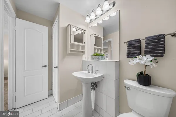 a bathroom with a toilet sink and mirror