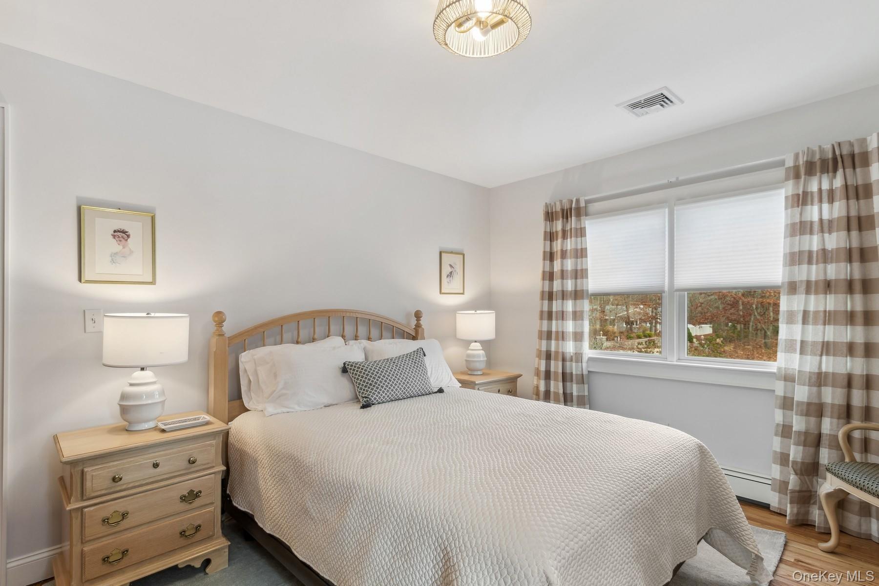 3 Debbie Trail Hampton Bays, NY 11946 - Photo 19 of 29 Bedroom featuring a baseboard radiator, wood finished floors, and visible vents