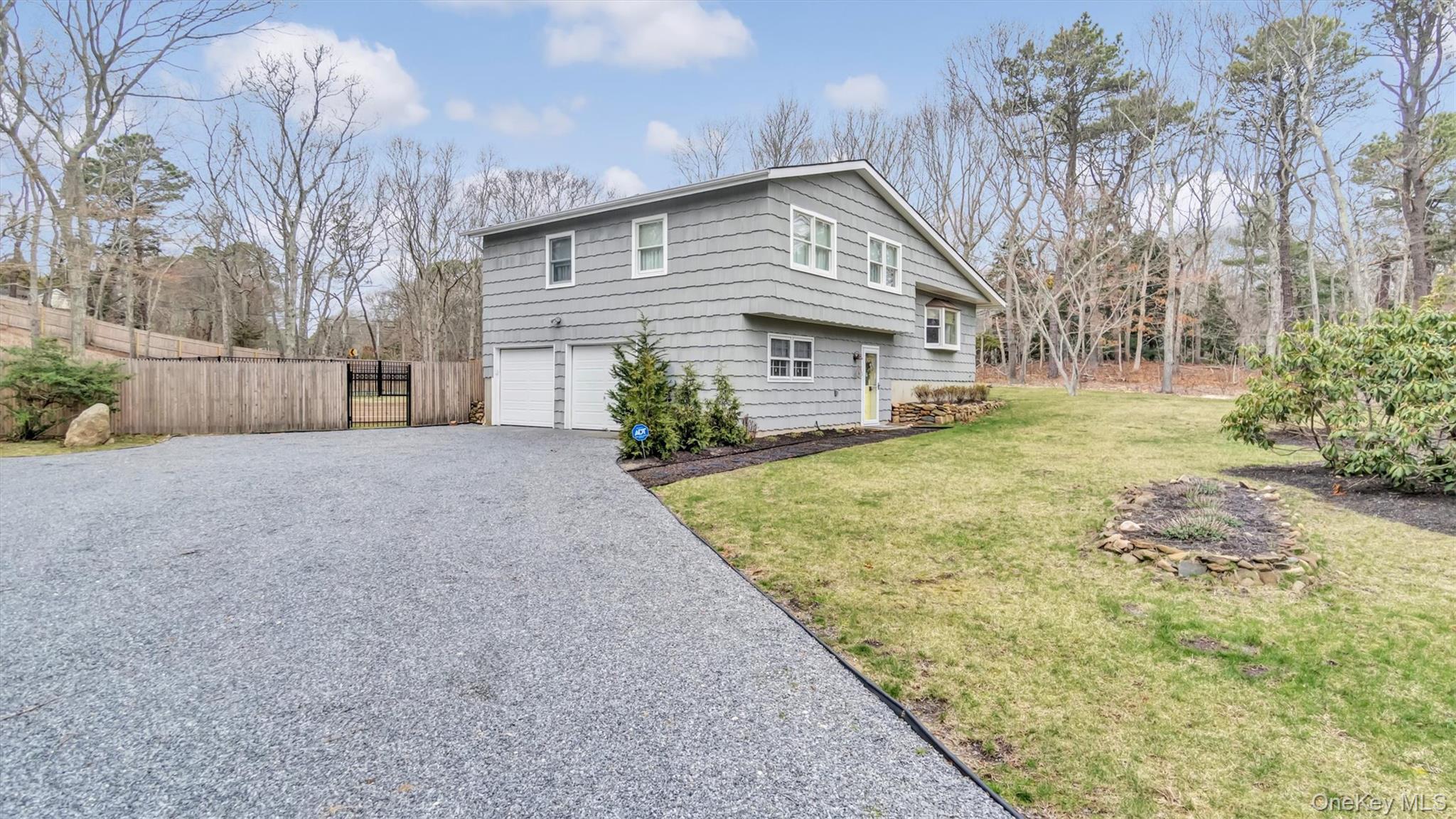 3 Debbie Trail Hampton Bays, NY 11946 - Photo 5 of 29 View of side of home with an attached garage, a lawn, aphalt driveway, and fence
