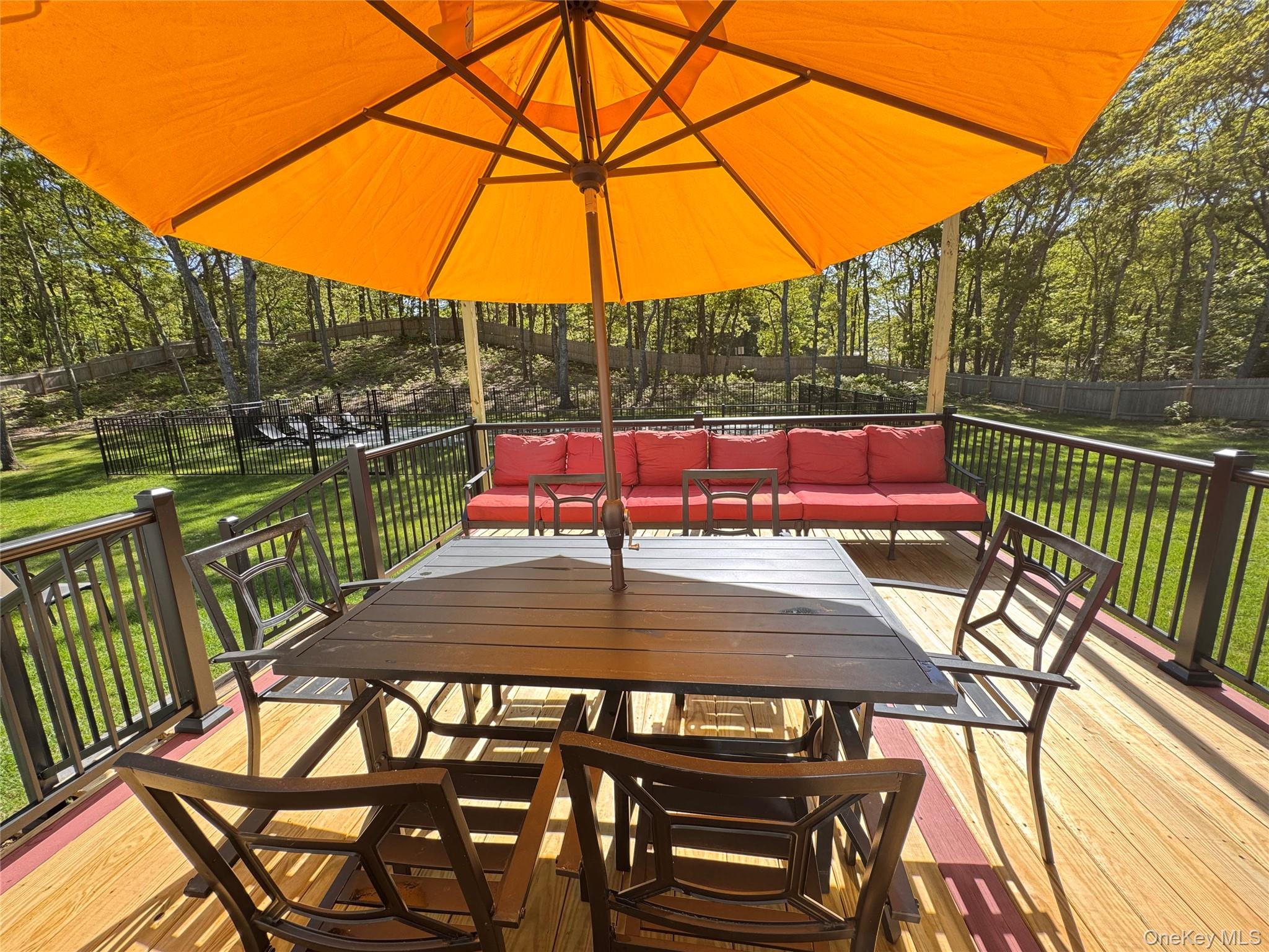 3 Debbie Trail Hampton Bays, NY 11946 - Photo 8 of 29 Wooden terrace with an outdoor living space, outdoor dining area, and view of wooded area