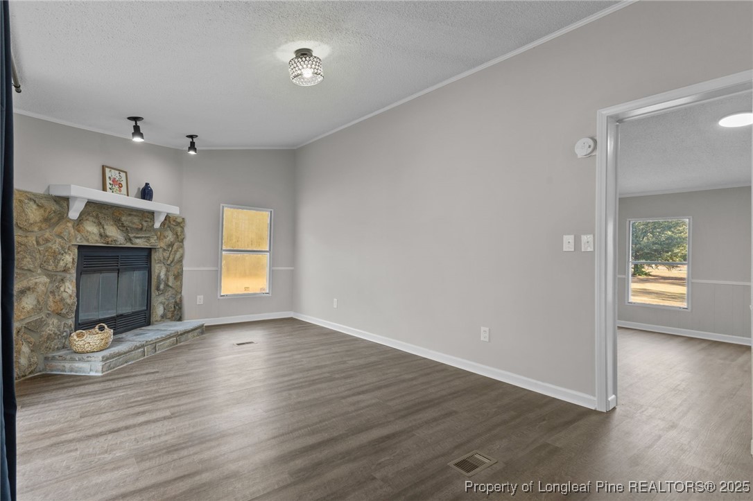 5888 Butler Nursery Road Fayetteville, NC 28306 - Photo 15 of 42 an empty room with wooden floor fireplace and windows