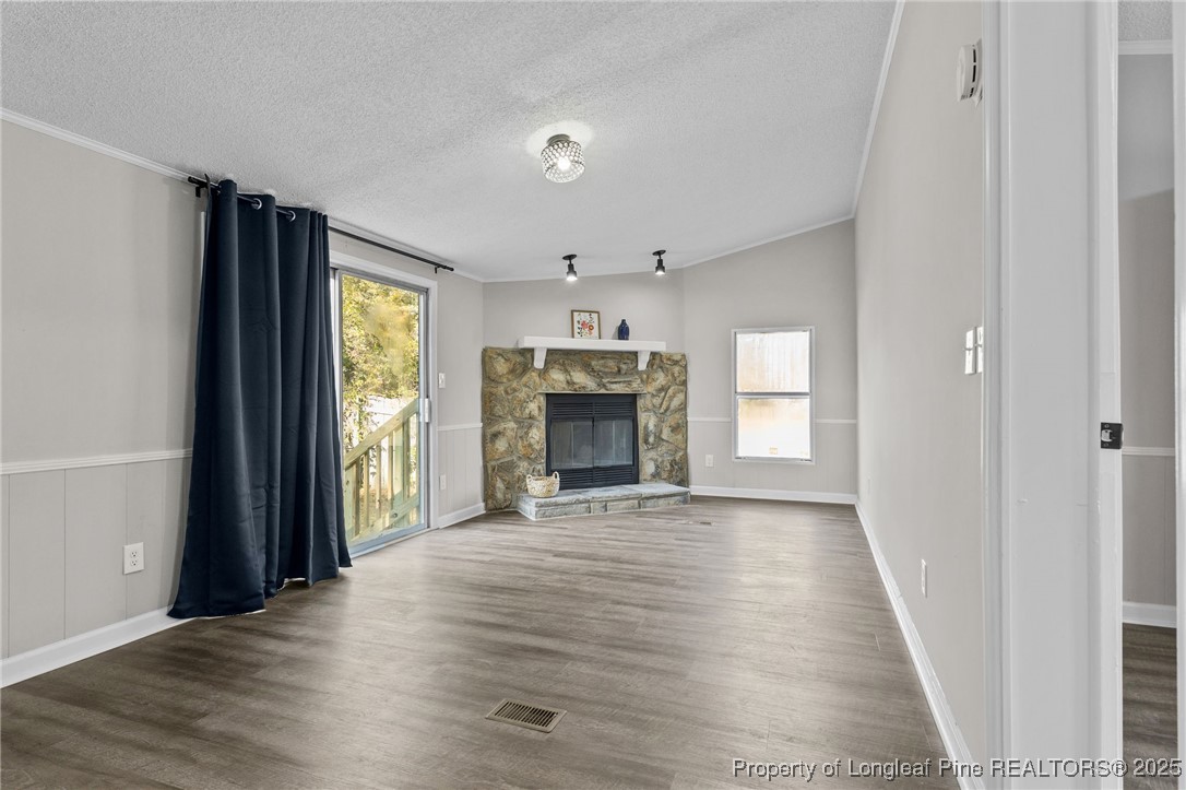 5888 Butler Nursery Road Fayetteville, NC 28306 - Photo 5 of 42 an empty room with wooden floor fireplace and windows