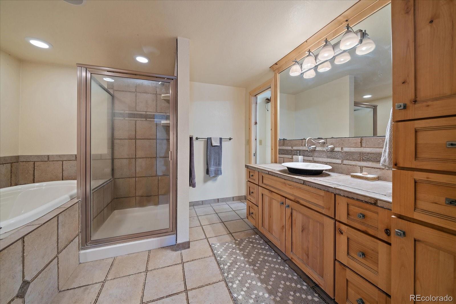 34 Normandy Road Evergreen, CO 80439 - Photo 27 of 45 a bathroom with a mirror a bathtub and a sink
