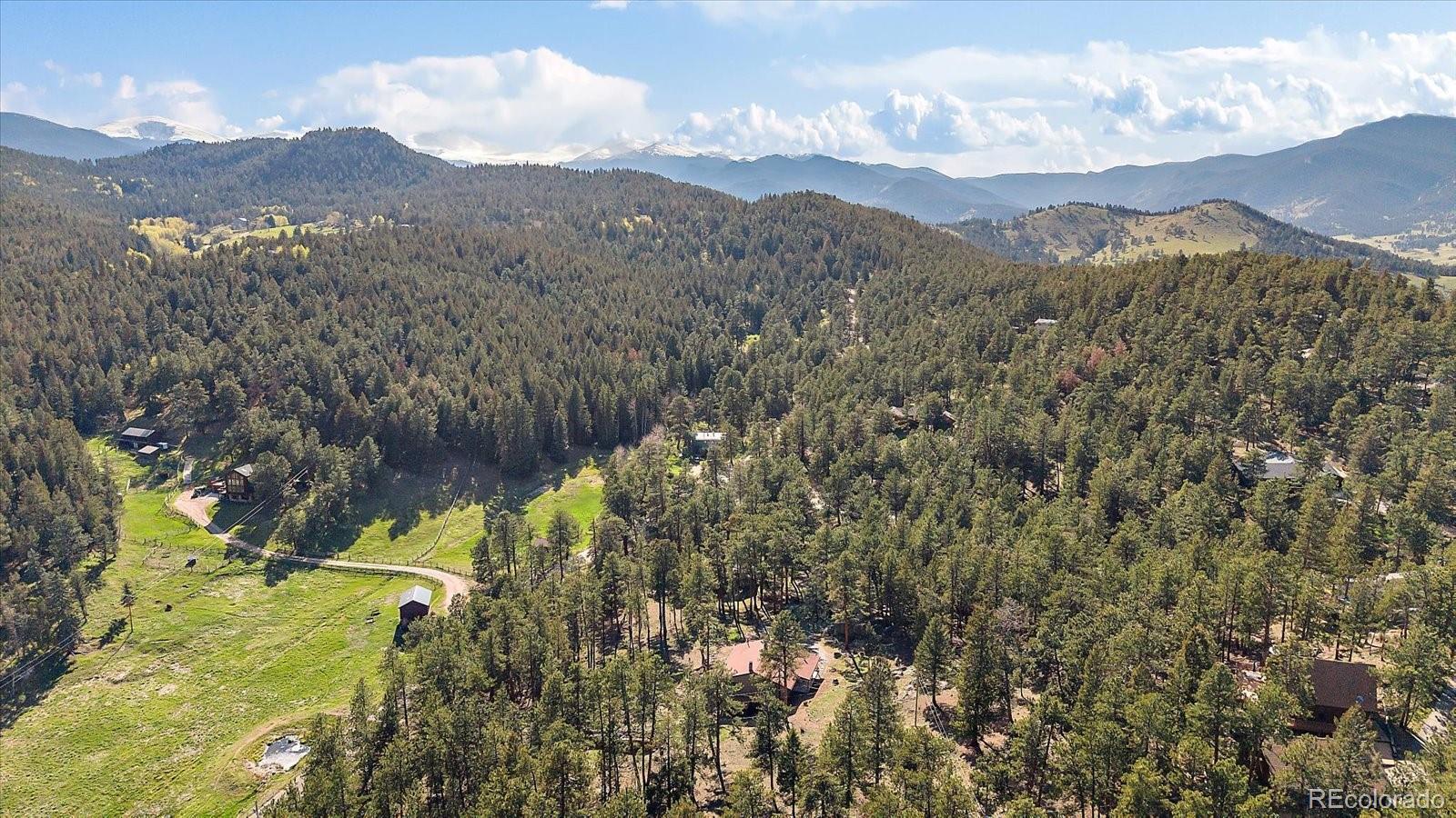 34 Normandy Road Evergreen, CO 80439 - Photo 39 of 45 a view of a lush green hillside and a mountain