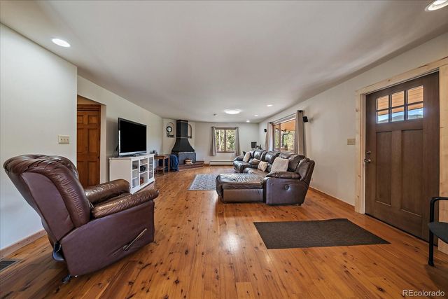 a dining room with wooden floor a chandelier a wooden table and chairs