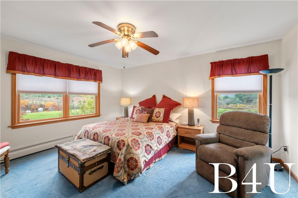 442 Fox Road Otego, NY 13825 - Photo 21 of 40 a bedroom with a bed and a chandelier