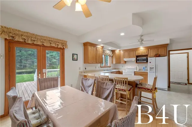 a kitchen with stainless steel appliances granite countertop a sink a stove a refrigerator a center island with wooden cabinets and floor