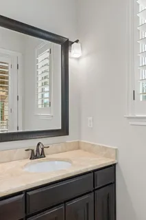 a bathroom with a granite countertop sink and a mirror