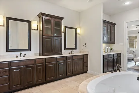 a spacious bathroom with double vanity and a mirror