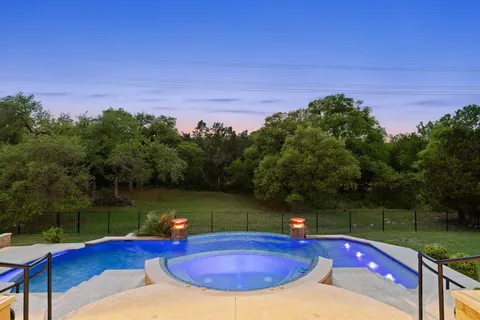 a swimming pool with trees in the background