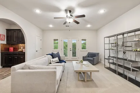 a living room with furniture a floor to ceiling window and a flat screen tv