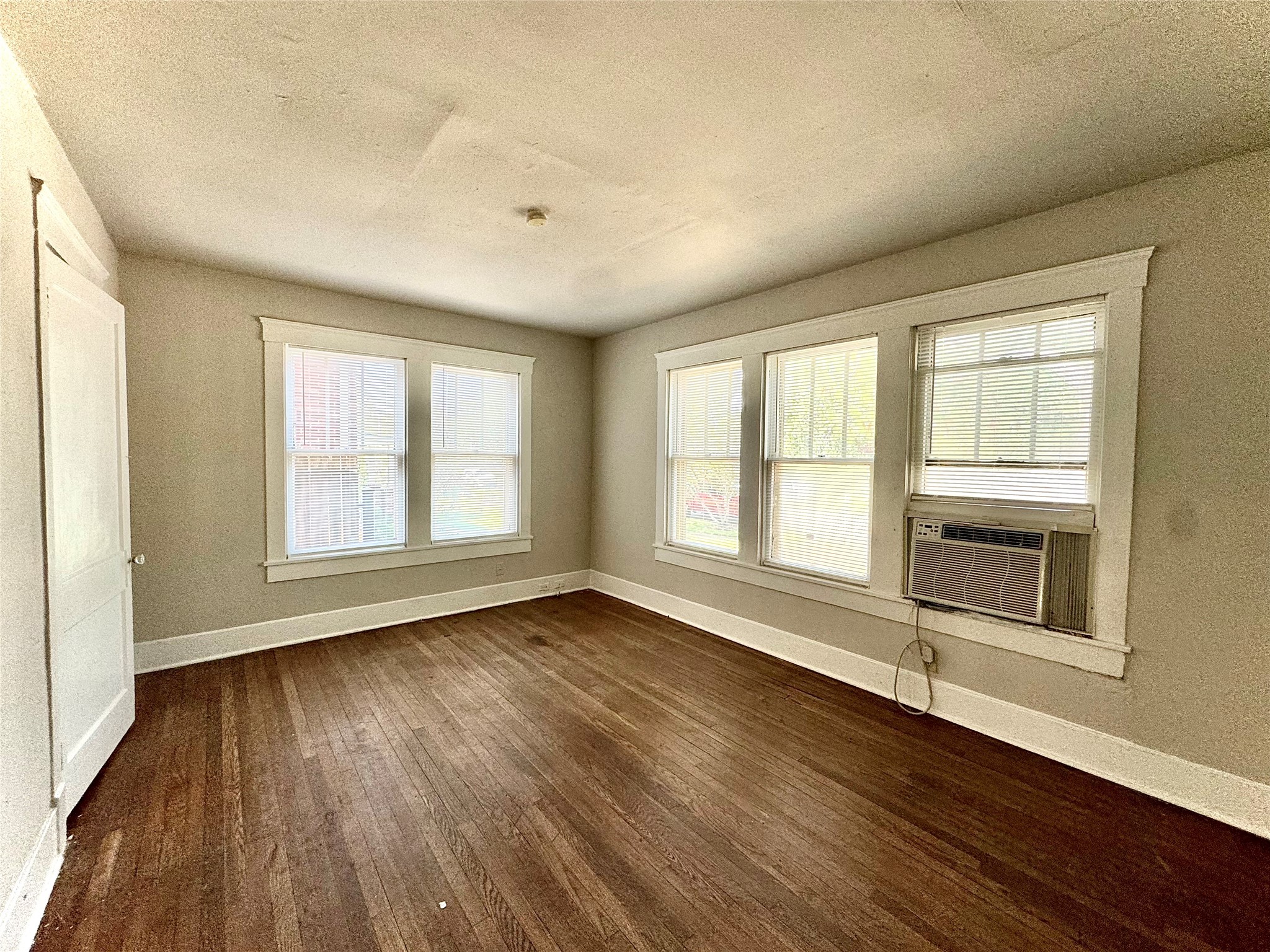 1711 West Main Street, Unit 2 Houston, TX 77098 - Photo 3 of 9 an empty room with wooden floor and windows