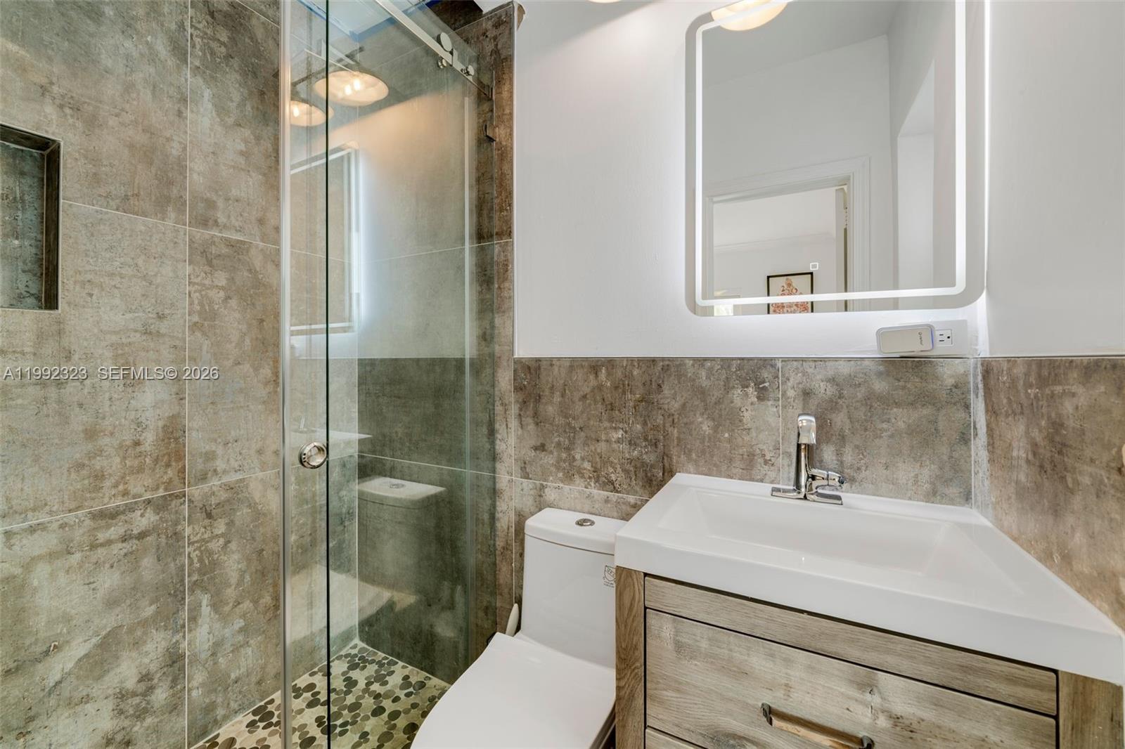 970 Northwest 10th Avenue Miami, FL 33136 - Photo 17 of 34 a bathroom with a sink a toilet and shower