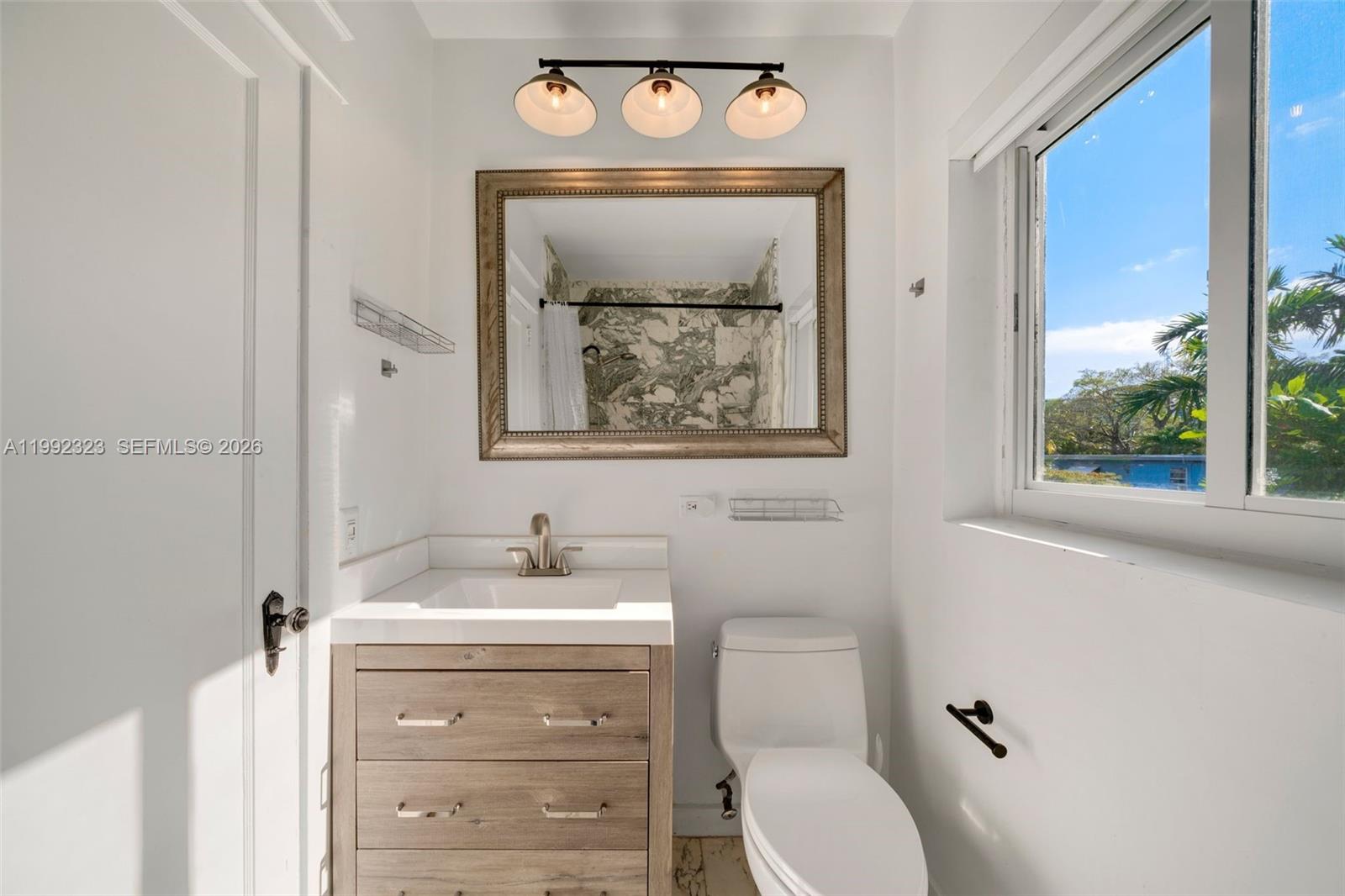 970 Northwest 10th Avenue Miami, FL 33136 - Photo 26 of 34 a bathroom with a toilet sink and mirror