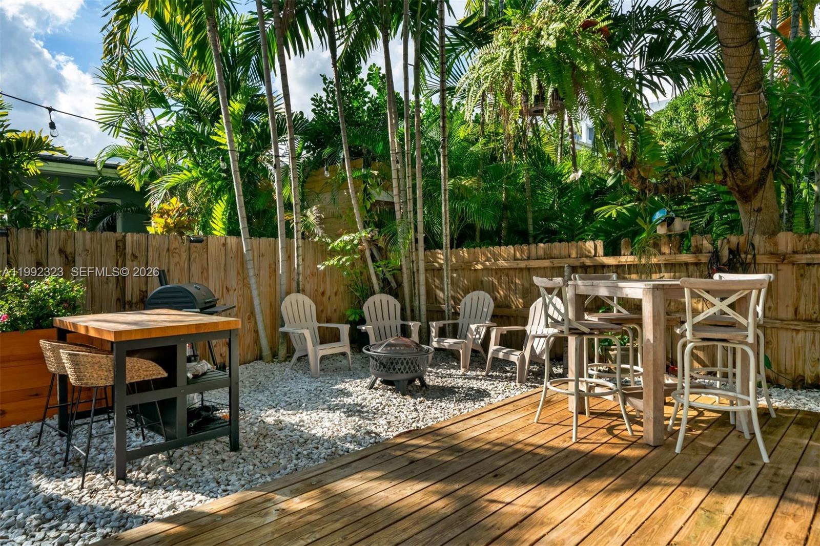 970 Northwest 10th Avenue Miami, FL 33136 - Photo 3 of 34 a view of a patio with table and chairs potted plants and palm tree