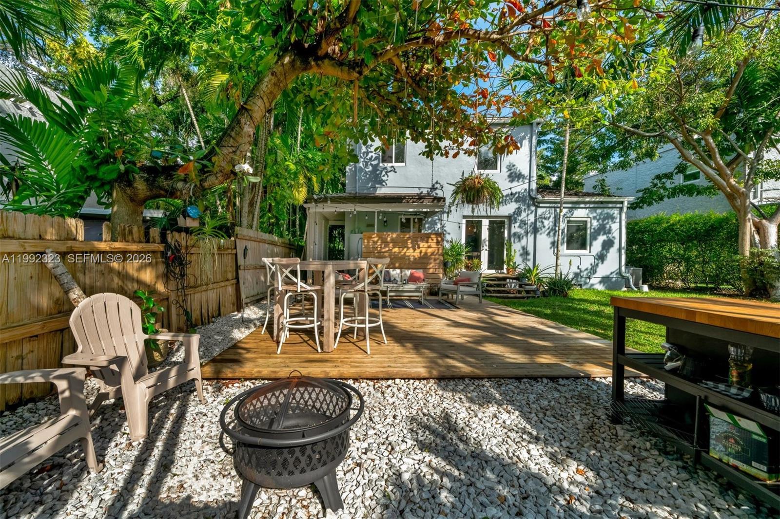 970 Northwest 10th Avenue Miami, FL 33136 - Photo 31 of 34 a view of a patio with table and chairs potted plants and large tree