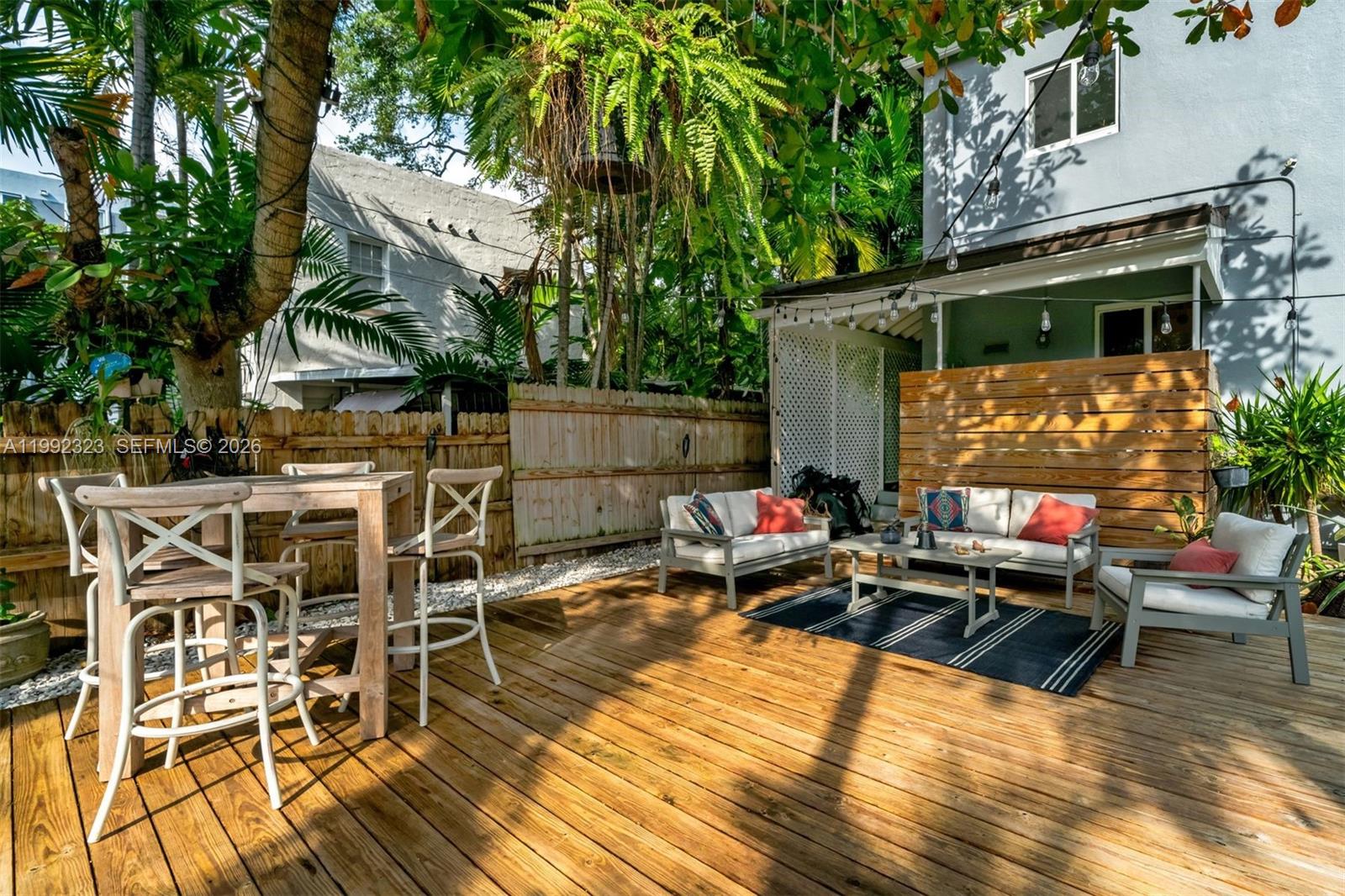 970 Northwest 10th Avenue Miami, FL 33136 - Photo 4 of 34 a view of a patio with table and chairs with wooden floor and fence