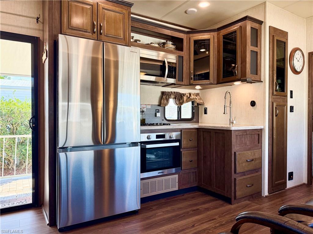 564 Cattleya Refuge, Unit 564 Naples, FL 34114 - Photo 23 of 50 a kitchen with stainless steel appliances granite countertop a refrigerator and a stove top oven