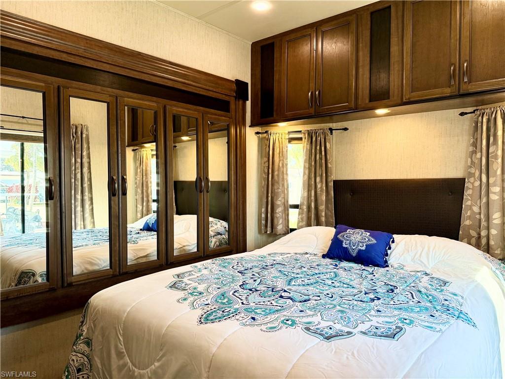 564 Cattleya Refuge, Unit 564 Naples, FL 34114 - Photo 25 of 50 a bedroom with a bed and wooden floor