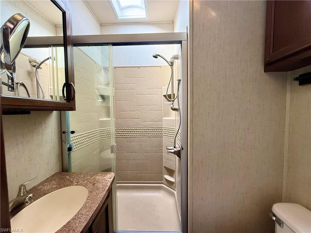 564 Cattleya Refuge, Unit 564 Naples, FL 34114 - Photo 30 of 50 a bathroom with a granite countertop sink toilet and shower