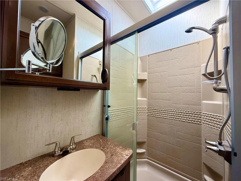 564 Cattleya Refuge, Unit 564 Naples, FL 34114 - Photo 32 of 50 a bathroom with a granite countertop sink a mirror and a toilet